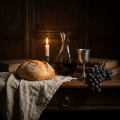 Candlelit still life with a loaf of bread, wine decanter, grapes, and old books.