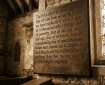 Wooden plaque with a G.K. Chesterton quote about fear and belief inside a stone church