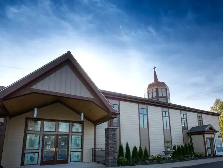 Landscape photo of Golgotha Baptist Church in Tacoma, WA, wide landscape with blue sky and church building centered.